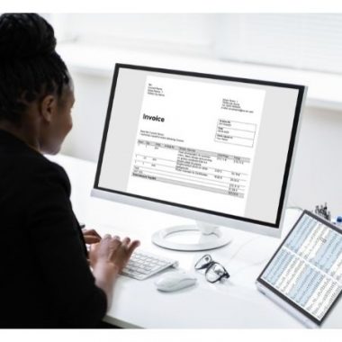 woman inputting data onto a computer screen invoice