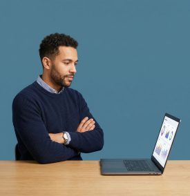 A focused business professional analyzing performance charts on a laptop, evaluating the ROI and value of a business website.