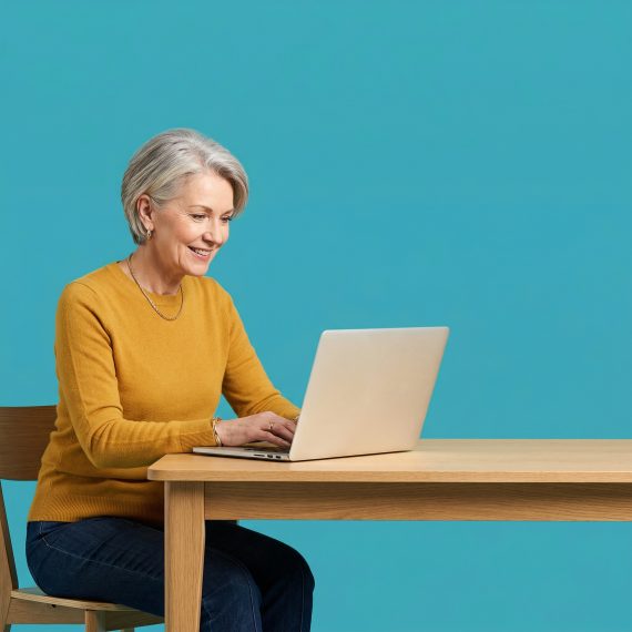 Smiling small business owner using a laptop to manage her company website against a blue background.