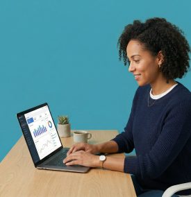 Small business owner at a desk looking focused at a laptop showing analytics data.