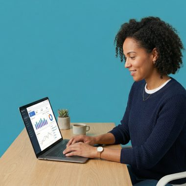 Small business owner at a desk looking focused at a laptop showing analytics data.