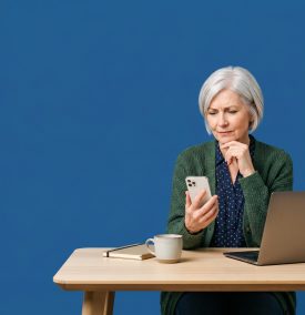 Small business owner looking at a phone with a thoughtful expression, plain white background.