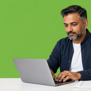 UK small business owner setting up a business email at a domain on a laptop, with a notepad of DNS settings beside the keyboard.