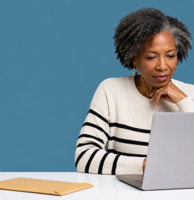 UK limited company director at a clean desk looking at a laptop with an unopened brown envelope nearby.