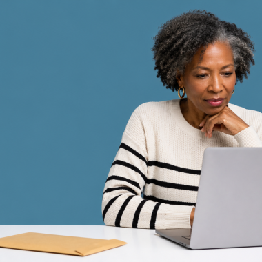UK limited company director at a clean desk looking at a laptop with an unopened brown envelope nearby.