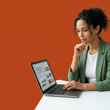 UK small business owner at a desk comparing email options on a laptop, looking thoughtful.