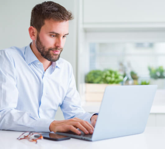 man in the office working on a laptop