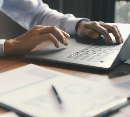 hands of a man typing on a laptop
